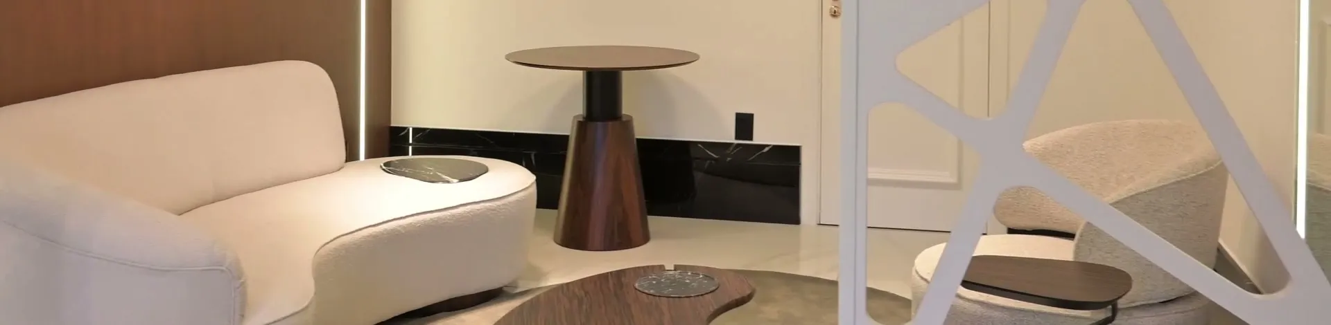 Sala de espera com sofá claro e mesa de madeira
